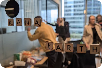 Kana Earth spelled out in scrabble tiles on an office window